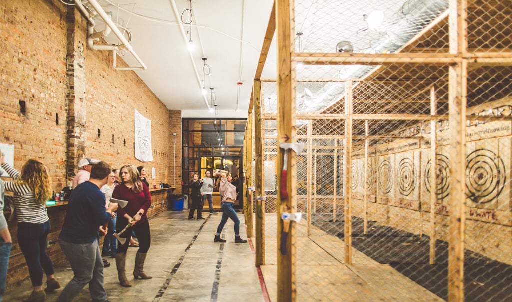 People socialize and throw axes as fun indoor activities at Valkyrie Axe Throwing.