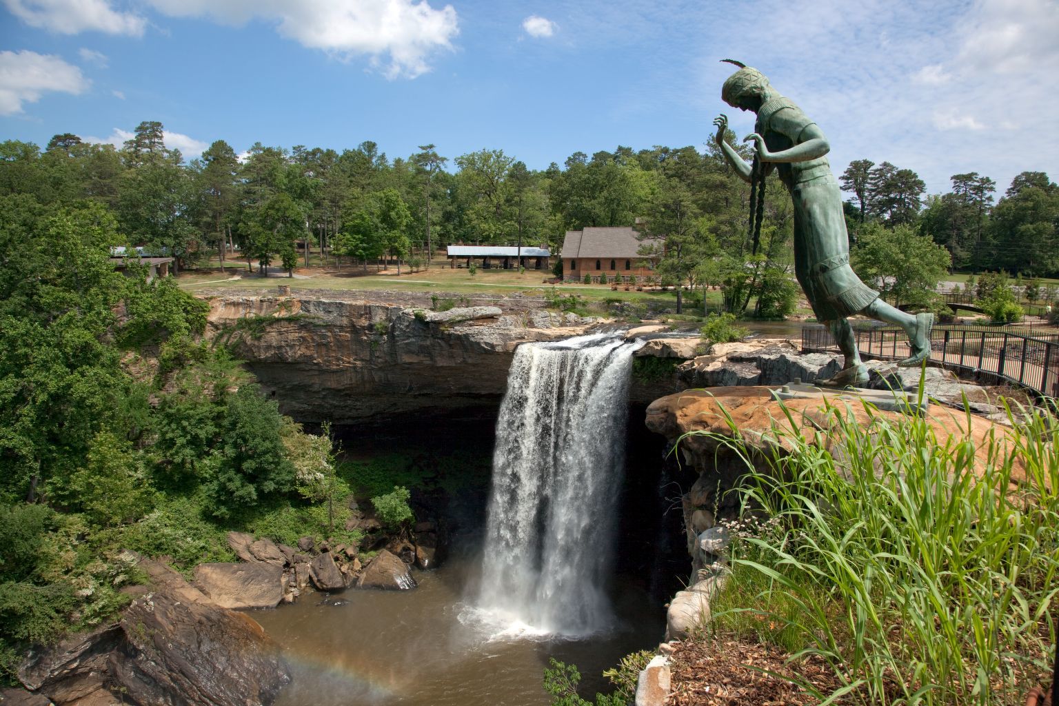 A waterfall and statue showing off the beauty at Noccalula Falls State Park as an option for a fun outdoor activity.
